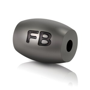 May include: A grey metal bead with the letters "FB" engraved on it.