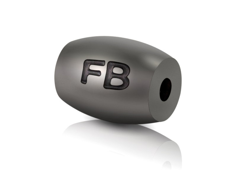 May include: A grey metal bead with the letters "FB" engraved on it.