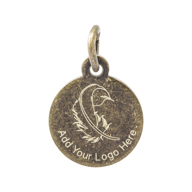 K&ouml;nnte beinhalten: Ein bronzefarbener, kreisf&ouml;rmiger Anh&auml;nger mit einer Schlaufe oben. Der Anh&auml;nger zeigt ein Federdesign und den Text "Add Your Logo Here" am Rand. Der Anh&auml;nger ist auf wei&szlig;em Hintergrund isoliert.