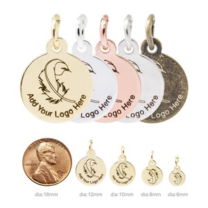 K&ouml;nnte beinhalten: Eine Auswahl an runden Metallanh&auml;ngern in verschiedenen Ausf&uuml;hrungen, darunter Gold und Silber. Jeder Anh&auml;nger hat ein Federdesign und den Text "Add Your Logo Here" oder "Logo Here". Gr&ouml;&szlig;en von 6 mm bis 18 mm Durchmesser.