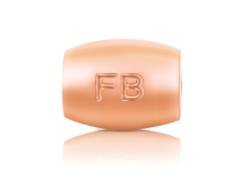 May include: A rose gold charm bead with the letters "FB" engraved on it.