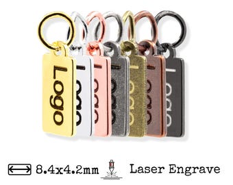 May include: A set of eight small, rectangular metal tags with a jump ring. The tags are in different colors: gold, silver, copper, bronze, and black. The tags are 8.4 x 4.2 mm and can be laser engraved with a logo. "Logo" is engraved on the gold tag.
