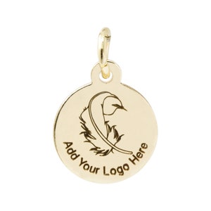 K&ouml;nnte beinhalten: Ein goldfarbener runder Anh&auml;nger mit Federdesign und dem Text "Add Your Logo Here". Der Anh&auml;nger hat oben eine kleine Schlaufe zum Befestigen an einer Kette. Die Feder ist schwarz ge&auml;tzt.