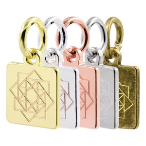 May include: Four square charms with a geometric design, each charm is a different color: gold, silver, rose gold, and antique brass.