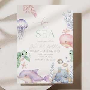 Puede incluir: Una invitación en colores pastel con temática acuática. El texto dice "Two the Sea" y "Mar 2nd Birthday". Ilustraciones de una medusa, tortuga, delfín, ballena e hipocampo rodean el texto. La invitación incluye detalles del evento.