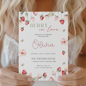 Puede incluir: Una invitación de boda con un diseño floral y de fresas. El texto dice "Berry in Love" e invita a los invitados a celebrar a la novia, Olivia. La invitación incluye la fecha, la hora y el lugar: The Wisteria House, Adelaida.