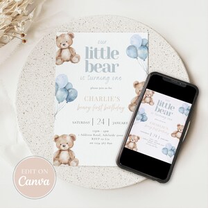 May include: A baby's first birthday invitation with a teddy bear theme. The invitation features the text "Our Little Bear is Turning One" with blue balloons and teddy bear illustrations. A smartphone displays the invitation.