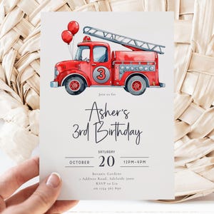 May include: A birthday invitation with a red watercolour fire engine, a ladder, and two red balloons. The invitation says "Asher's 3rd Birthday" with event details including the date, time, and location.