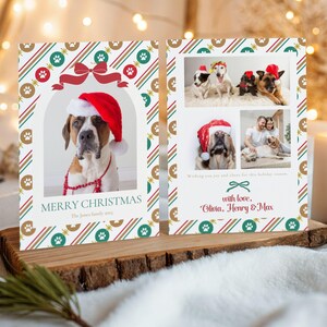 Op de afbeelding: Een kerstkaart met een Sint-Bernardus met een kerstmuts en de tekst "MERRY CHRISTMAS". De kaart heeft een feestelijk ontwerp met pootafdrukken en een lint. De rechterkant toont foto's van honden en mensen.