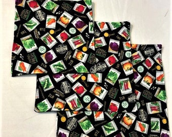 Protectores de sartenes: paquetes de semillas de verduras sobre fondo negro