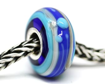 May include: Blue and white glass bead with silver accents. The bead has a swirl pattern and is on a silver chain.