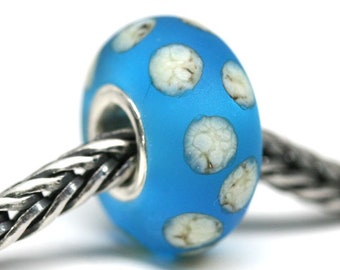 May include: A blue glass bead with white polka dots, strung on a silver chain.