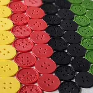 Peut inclure: Gros plan sur une collection de boutons colorés disposés en motif. Les boutons sont rouges, jaunes, noirs et verts. Chaque bouton porte l'inscription "SAMPLE TEXT".