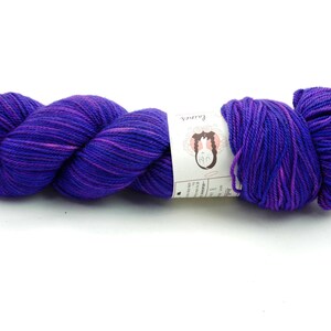 May include: A skein of purple and pink hand-dyed yarn with a white label that reads "Fair Isle".