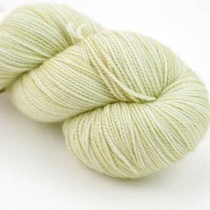 May include: A skein of light green yarn with white flecks.