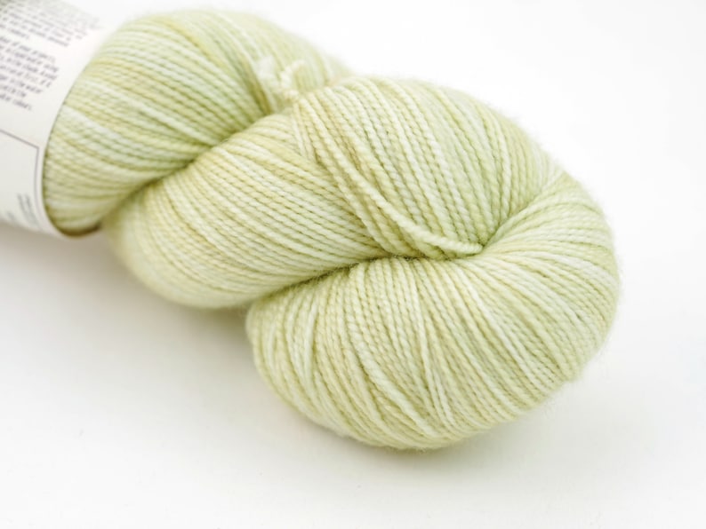 May include: A skein of light green yarn with white flecks.