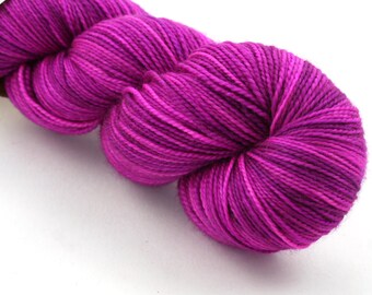 May include: A skein of magenta and purple yarn with a variegated color pattern.