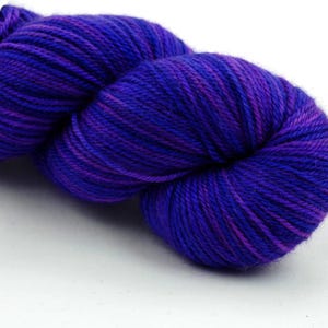 May include: A skein of purple and blue yarn with a white label that says "49 Knitterly" and "Superwash Merino".