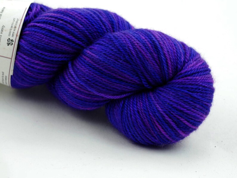 May include: A skein of purple and blue yarn with a white label that says "49 Knitterly" and "Superwash Merino".