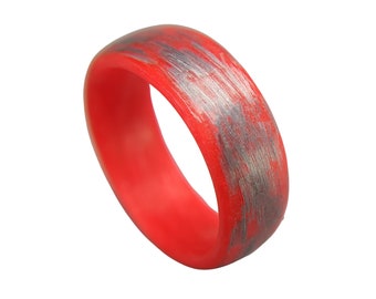Puede incluir: Un anillo de silicona rojo con un patrón de mármol plateado y gris.