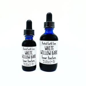 May include: Two bottles of white willow bark lunar tincture, one 1 oz bottle and one 2 oz bottle, both with blue glass bottles and black dropper caps. The labels are white with black text that reads "Rooted Earth Farm" and "White Willow Bark Lunar Tincture".