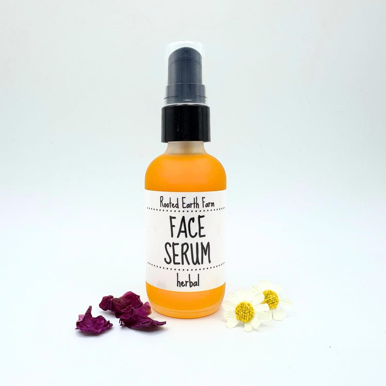 May include: A clear glass bottle with a black pump top filled with a yellow liquid. The bottle has a white label that reads "Rooted Earth Farm Face Serum herbal".