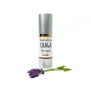 Pode incluir: Um frasco prateado com um r&oacute;tulo branco que diz "Rooted Earth Farm CHAGA face serum lavender". Um ramo de lavanda est&aacute; em primeiro plano.
