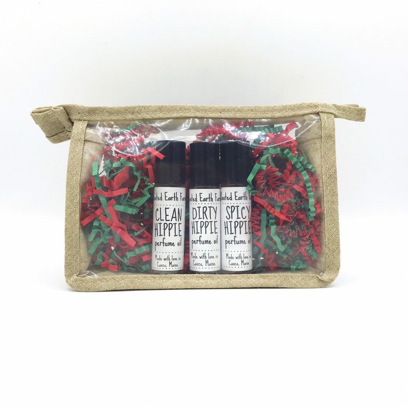 Pu&ograve; includere: Tre piccoli flaconi di vetro con tappi neri ed etichette bianche. Le etichette riportano "Clean Hippie", "Dirty Hippie" e "Spicy Hippie" con le parole "perfume oil" sotto. I flaconi sono in un sacchetto di plastica trasparente con carta triturata rossa e verde.