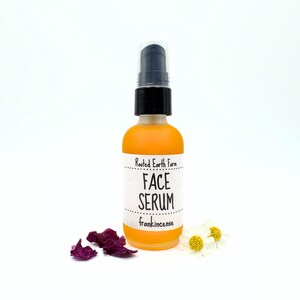May include: A clear glass bottle with a black pump top filled with a yellow liquid. The bottle has a white label that reads "Rooted Earth Farm Face Serum frankincense".