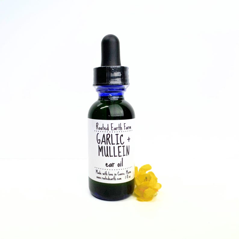 Puede incluir: Una peque&ntilde;a botella de vidrio verde oscuro con un gotero azul. La botella est&aacute; etiquetada "Rooted Earth Farm GARLIC + MULLEIN ear oil". Hecho con amor en Cave, MN. www.rootedearth.com