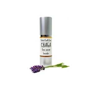 Pode incluir: Um frasco prateado com um r&oacute;tulo branco que diz "Rooted Earth Farm CHAGA face serum lavender". Um ramo de lavanda est&aacute; em primeiro plano.