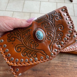 Cartera de cuero con herramientas manuales y pieza central turquesa