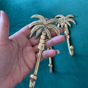 Puede incluir: Dos ganchos de metal dorados en forma de palmera. Los ganchos est&aacute;n hechos de metal y tienen un dise&ntilde;o detallado de palmera. Los ganchos son perfectos para colgar toallas, batas u otros art&iacute;culos en un ba&ntilde;o o dormitorio.