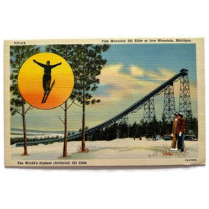 May include: Vintage postcard featuring the Pine Mountain Ski Slide in Iron Mountain, Michigan. The image shows a skier in mid-air within a yellow circle, and the ski jump structure. Text reads "The World's Highest (Artificial) Ski Slide."