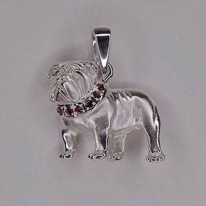 May include: Silver bulldog pendant with a red gemstone collar.