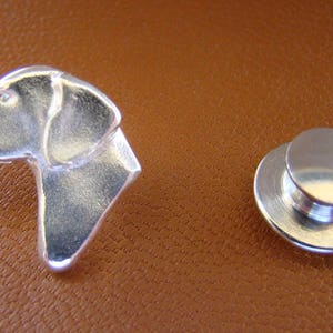 May include: Silver-toned dog head lapel pin with a matching silver-toned magnetic back.