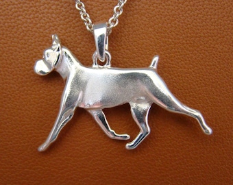Puede incluir: Collar con colgante de plata con un diseño de perro Boxer tridimensional detallado. El perro está representado en una pose de carrera con la cabeza girada hacia un lado.