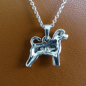 May include: Silver pendant necklace featuring a detailed silhouette of a dog. The pendant has a hallmark on the back.
