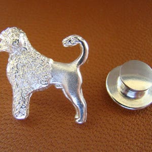 Puede incluir: Pin de perro caniche plateado con acabado texturizado. El pin tiene un cierre de poste y embrague.