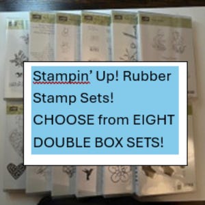 May include: A collection of Stampin' Up! rubber stamp sets in clear packaging. The image includes text that reads "Stampin' Up! Rubber Stamp Sets! CHOOSE from EIGHT DOUBLE BOX SETS!" The stamps feature various designs.