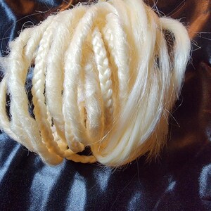 May include: A bundle of blonde synthetic hair extensions, braided and ready to be added to a hairstyle.