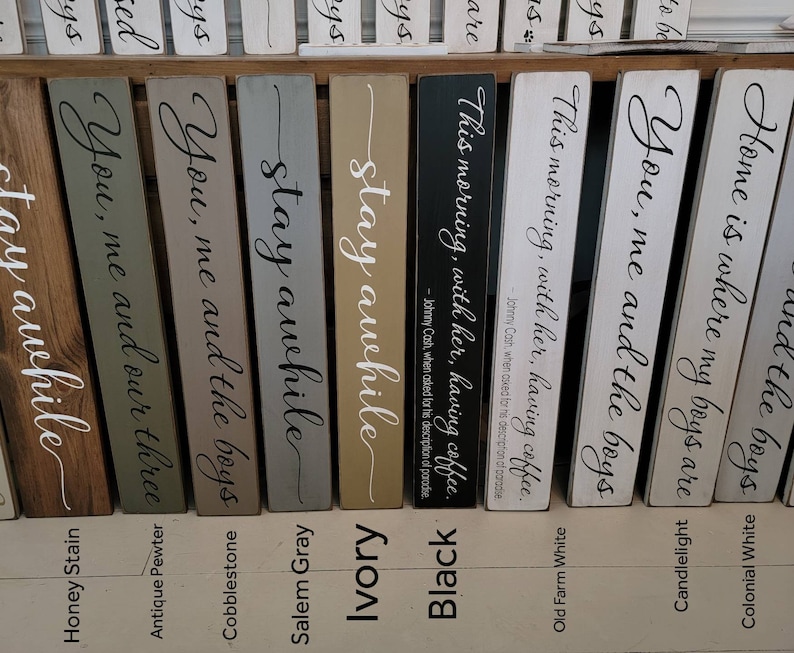 Peut inclure: Dix panneaux en bois avec des dictons et des couleurs diff&eacute;rents. Les panneaux sont tous de la m&ecirc;me taille et de la m&ecirc;me forme. Les dictons incluent "You, me and the boys", "Stay awhile", "This morning, with her, having coffee", et "Home is where my boys are".