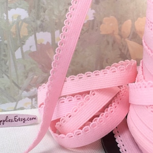 May include: Pink elastic trim with a scalloped edge. The trim is shown rolled up on a spool. The text "MarySupplies.Etsy.com" is visible on a white surface.