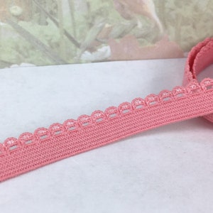 May include: Pink elastic trim with a scalloped edge. The trim is about 1 inch wide.