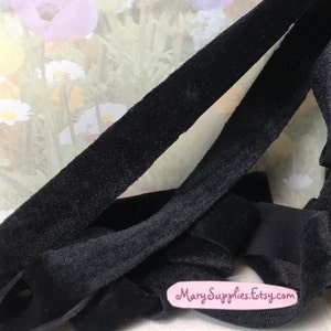 May include: Black velvet ribbon with a soft, plush texture. The ribbon is folded and layered, showcasing its smooth surface. The image includes the text "MarySupplies.Etsy.com".