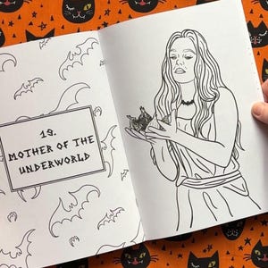 Pu&ograve; includere: Illustrazione in bianco e nero da un libro da colorare. La pagina mostra una donna che tiene in mano un gruppo di oggetti, con il testo "19. MOTHER OF THE UNDERWORLD" in un riquadro rettangolare. I pipistrelli sono disegnati intorno al testo.
