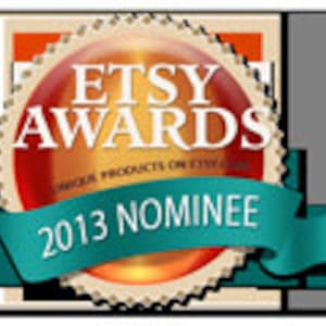 May include: A gold and red Etsy Awards nominee badge with a teal ribbon that says "2013 Nominee".