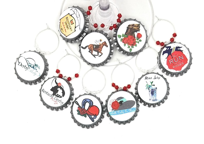 May include: Set of ten silver-colored wine glass charms with red and white designs. The charms feature images of horses, roses, a jockey, a mint julep, and the text "Kentucky Derby" and "Run for the Roses".