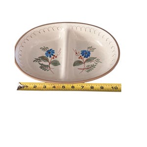 Puede incluir: Fuente ovalada dividida con interior crema y borde marrón. Presenta diseños florales azules y hojas verdes. La fuente mide aproximadamente 25 cm de largo.