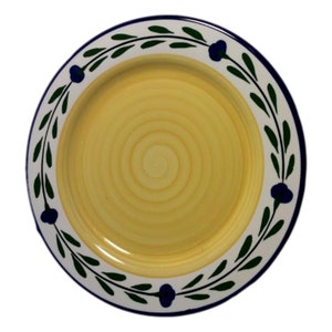 May include: A yellow ceramic dinner plate with a white rim and a green and blue floral design.